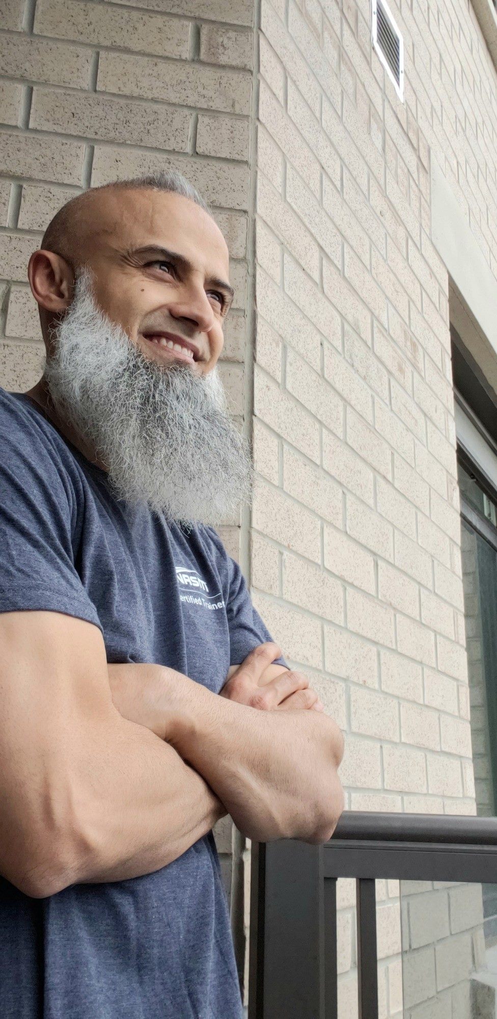 Nadeem Tejani, exercise therapist, smiling with arms crossed
